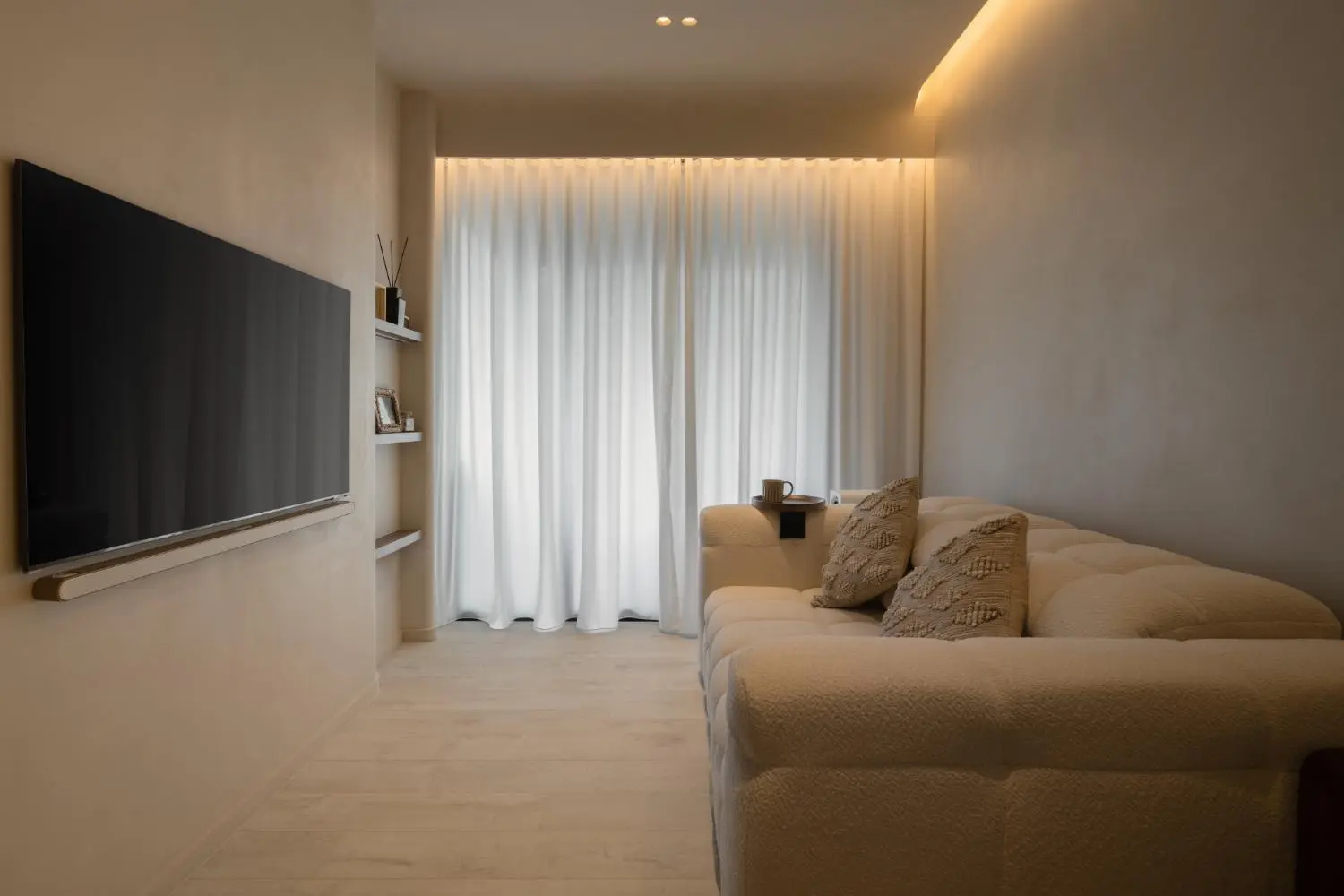 Living room from sofa — TV wall, floating shelves and sheer curtains