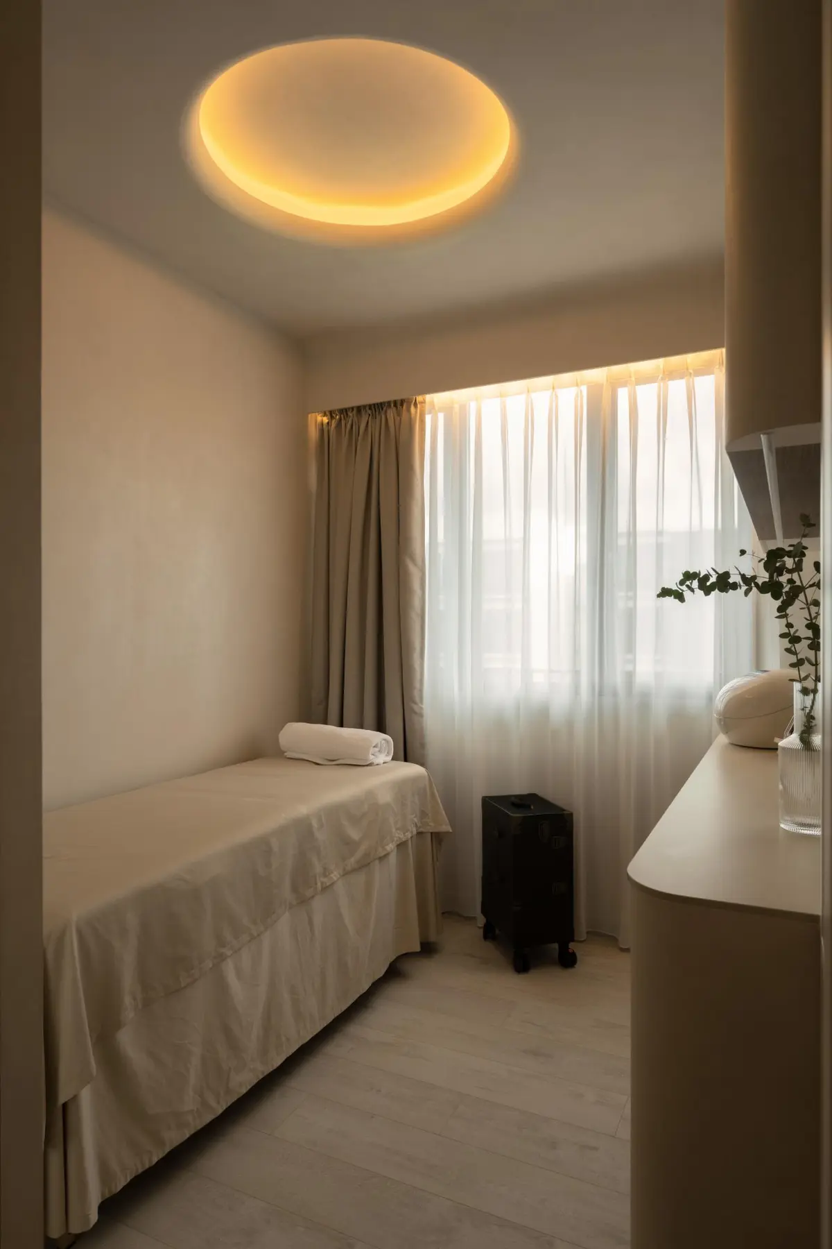 Treatment room portrait — circular cove ceiling light, microplaster walls and natural light